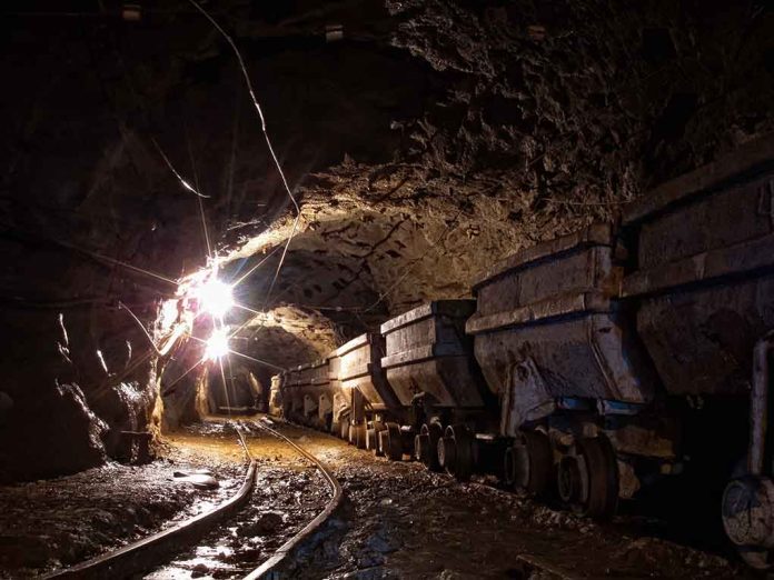 537303439 featured image Dimly lit mine shaft with rail carts and tracks.