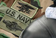 U.S. Navy badges on camouflage uniform with boot