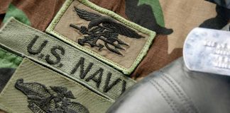 U.S. Navy badges on camouflage uniform with boot