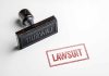 Rubber stamp labeled lawsuit on white background