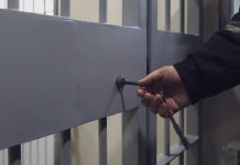 Hand unlocking metal jail cell door with key