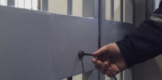 Hand unlocking metal jail cell door with key