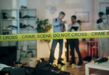 Crime scene with tape and investigators examining evidence