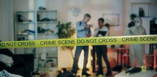 Crime scene with tape and investigators examining evidence