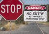 Stop and Danger signs on a chain-link fence