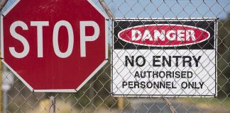 Stop and Danger signs on a chain-link fence
