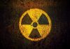 Yellow radiation warning symbol on rusty metal surface