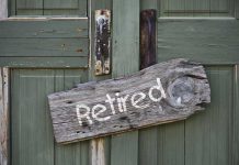 Rustic retired sign on green wooden door