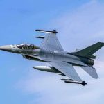 Jet fighter flying through clear blue sky