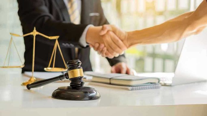 Hands shaking over legal documents with gavel and scales