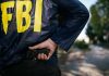FBI agent holding a gun behind the back