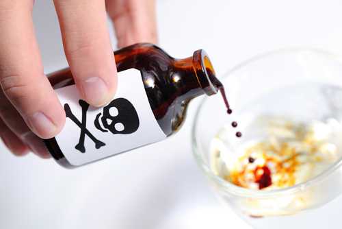 Person pouring liquid from poison bottle into glass