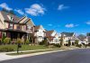 A row of modern suburban houses under a clear blue sky