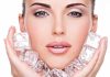 Close up of a woman holding ice cubes around her face