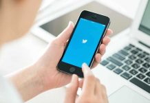 Person holding a smartphone displaying the Twitter app