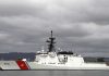 A US Coast Guard ship docked under cloudy skies