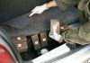 Person discovering wrapped packages in a car trunk.