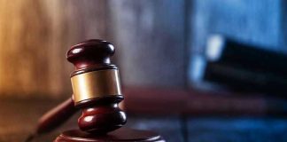 Gavel on wooden table in dimly lit room