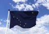 Alaska state flag flying against a blue sky