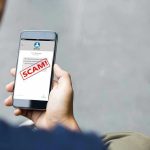 Person reading a scam message on a smartphone.