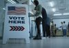 Sign reading Vote Here in a polling station.