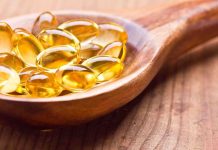 Golden omega3 capsules in a wooden spoon