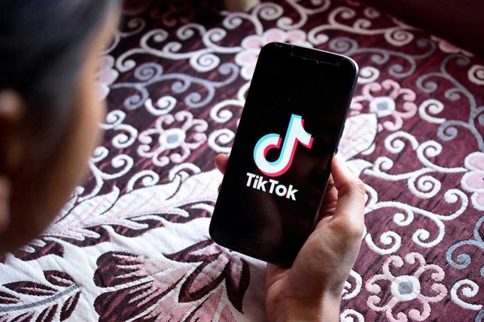 Hand holding phone showing TikTok logo.