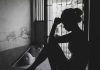Silhouetted person sitting by a window, deep in thought.