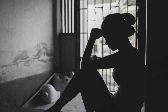 Silhouetted person sitting by a window, deep in thought.