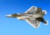 Fighter jet in flight against a clear blue sky.