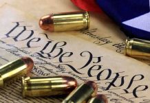 Close-up of bullets surrounding a historical document with the phrase We the People