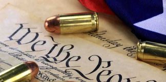 Close-up of bullets surrounding a historical document with the phrase We the People