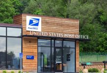 Bomb Squad STORMS USPS—Mailed Package Threat! Exterior view of a modern United States Post Office building surrounded by greenery