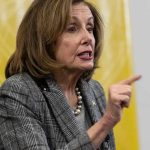 Pelosi RETIRES — Trump’s Brutal Response STUNS Woman speaking and pointing, wearing a plaid jacket.