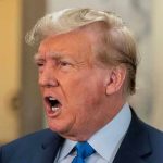 BASEBALL BAT Attack Rocks Trump Lawyer’s Office Man in suit with open mouth, speaking passionately.