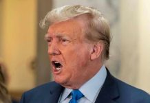 BASEBALL BAT Attack Rocks Trump Lawyer’s Office Man in suit with open mouth, speaking passionately.