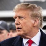 Mamdani THREATENS Trump – Issues Direct Warning Man in suit and red tie speaking outside.