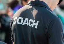 Person wearing a shirt labeled Coach.