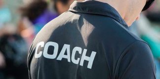 Person wearing a shirt labeled Coach.