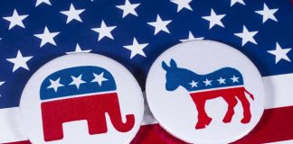 Republican elephant and Democrat donkey on American flag.