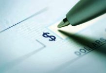 Close-up of a pen poised over a check with a dollar sign