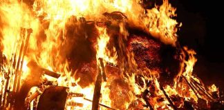 A large fire engulfing debris at night