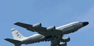 Military aircraft flying in clear blue sky.
