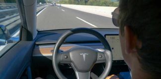 Person using autopilot in Tesla on highway.