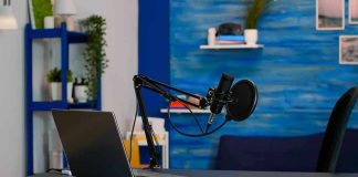 Laptop and a microphone on a desk.