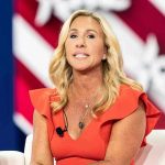 MTG Reveals What Congress REALLY Think Of Trump Woman speaking at an event, wearing a red dress.