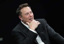 Musk’s SHOCKING $1.5 Trillion IPO Bombshell Man in suit smiling, resting chin on hand.
