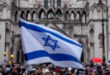 Tunnel Hanukkah Horror Shocks World Israeli flag at a crowded outdoor event.