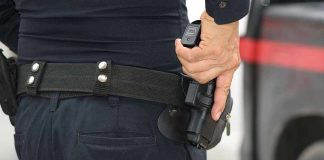 Person holding a gun in a holster.