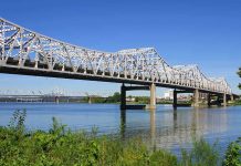 Trooper’s Daring Bridge Rescue – Unbelievable! A large metal bridge spanning over a river with a clear blue sky in the background